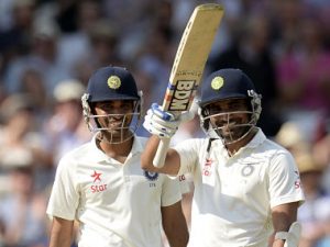 India's Shami waves his bat after reaching his half century as he stands with team-mate Kumar during the first cricket test match against England at Trent Bridge cricket ground in Nottingham